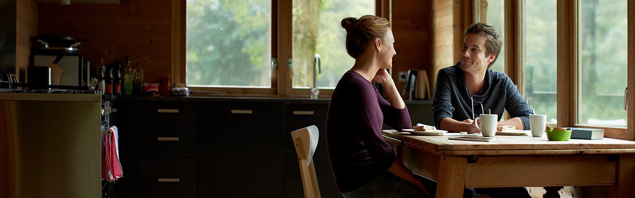 Two people talking through plans together at a table